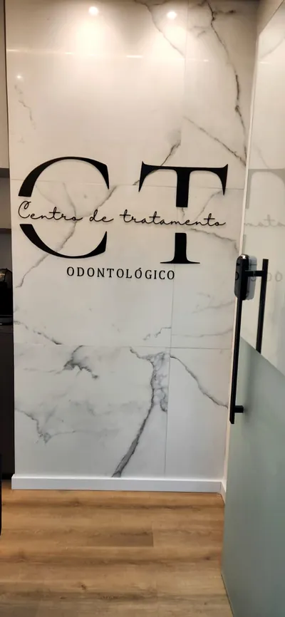 Recepção da CT Odonto com parede de mármore e logotipo, nas Graças, Recife